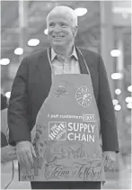 ?? DEIRDRE HAMILL/REPUBLIC FILE ?? Left: McCain shows off his apron after talking to employees at the Home Depot Rapid Deployment Center in Tolleson. The newly opened rapid-deployment center was 466,000 square feet.