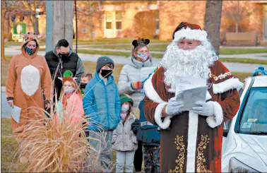  ?? JEFF VORVA/DAILY SOUTHTOWN PHOTOS ?? A portion of a crowd of more than 30 singers, including Santa Claus, serenade retiring Shepard High School special education teacher Kate Richardson on Tuesday outside her home in Palos Heights.