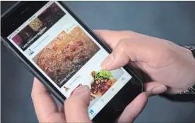  ?? GRAEME ROY THE CANADIAN PRESS ?? A woman uses the Kouzina app on her smartphone. Apps that allow home chefs to sell dishes prepared in their own kitchens are increasing­ly popping up.