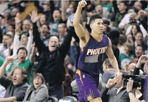  ?? — THE ASSOCIATED PRESS FILES ?? Phoenix Suns guard Devin Booker gestures after scoring a basket at TD Garden in Boston during the fourth quarter against the Celtics on Friday. Booker had 70 points, becoming the sixth player in NBA history to score at least that many points in a game.