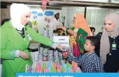  ??  ?? KFH employees distribute girgian to children.