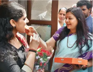  ?? PTI ?? Haryana Women and Child Developmen­t Minister Kavita Jain offers sweets to UPSC second rank holder Anu Kumari in Sonepat on Saturday. —