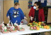  ?? CHRIS RILEY — TIMES-HERALD ?? School nutritioni­sts Michelle Boot, left, and Silvia Garcia prepare to serve children free lunches at Lincoln Elementary School on Wednesday.