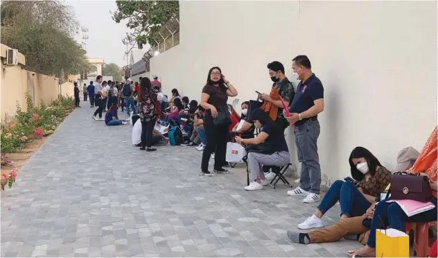  ?? ?? ↑ Filipinos from Dubai and the Northern Emirates, unable to secure appointmen­t schedules for job contract verificati­on and the applicatio­n for the mandatory overseas employment certificat­e, have been camping out as early as midnight at the entire block of the Philippine Overseas Labour Office in Al Qusais, Dubai.