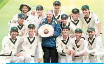  ??  ?? ADELAIDE: The Australian team celebrates with the trophy after Australia defeated Pakistan on the fourth day of the second cricket Test match in Adelaide yesterday. —AFP