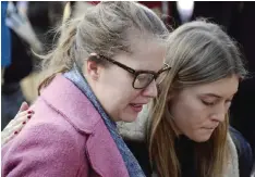  ??  ?? PARIS: Women comfort each other as they gather with others at a memorial site yesterday outside of the La Belle Equipe, in the 11th district of Paris, for victims of the November 13 attacks in Paris. — AFP