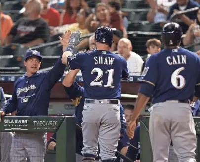  ?? MARK J. REBILAS / USA TODAY SPORTS ?? Brewers manager Craig Counsell greets Travis Shaw and Lorenzo Cain after Shaw’s two-run home run off Matt Koch on Wednesday.