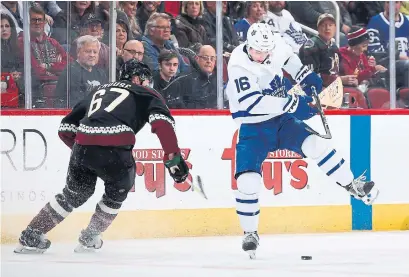  ?? CHRISTIAN PETERSEN GETTY IMAGES ?? Mitch Marner attempts to control the puck ahead of Lawson Crouse of the Arizona Coyotes during Saturday’s game.