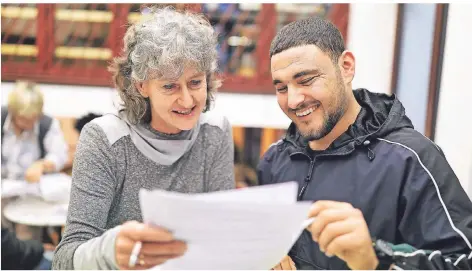  ?? RP-FOTO: STEPHAN KÖHLEN ?? Karin Weidener (links) hilft Sabri Aziz beim Ausfüllen von Formularen.