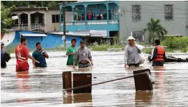  ?? DELMER MARTINEZ AP ?? Men wade through a flooded street after the passing of Hurricane Iota in La Lima, Honduras, on Wednesday. After it hit Nicaragua as a Category 4 storm on Monday, Iota flooded stretches of Honduras still underwater from Hurricane Eta.