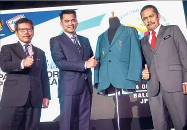  ??  ?? Dressed for success: Deputy Home Minister Datuk Mohd Azis Jamman (centre) together with Mohammad Razin (right) unveiling the new department uniform in Putrajaya. Also present is ministry secretary-general Datuk Seri Alwi Ibrahim.
