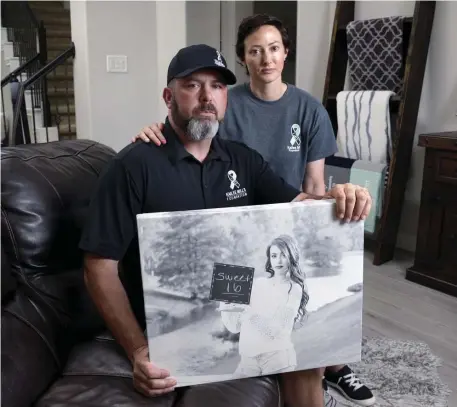  ?? AP ?? TRAGIC: David and Wendy Mills, parents of Kailee Mills who was killed four years ago in an automobile accident when riding in the back seat without a seat belt, pose with a photo of their daughter at their home in Spring, Texas.