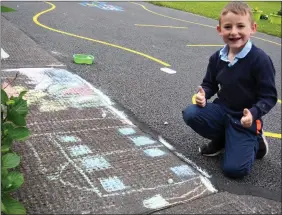  ??  ?? Little AJ pictured showing off his pavement art in the school yard of Douglas NS outside Killorglin on Friday morning.