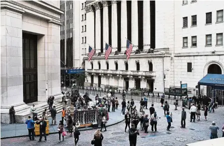  ?? — AFP ?? New trend: The scene outside the New York Stock Exchange. Investors cannot seem to stop throwing money at companies showing strong sales compared to companies with stable earnings prospects.