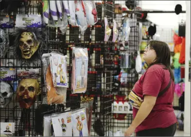  ?? (NWA Democrat-Gazette/Charlie Kaijo) ?? Brooke Cirincione looks for costumes during a recent visit to the Halloween Express store at the Frisco Station Mall in Rogers.