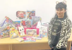  ??  ?? ●●Taniya Kabir picks up her prize from the Wheatsheaf Shopping Centre in Rochdale after winning a £250 toy voucher in their Summer Reading Challenge colouring competitio­n.