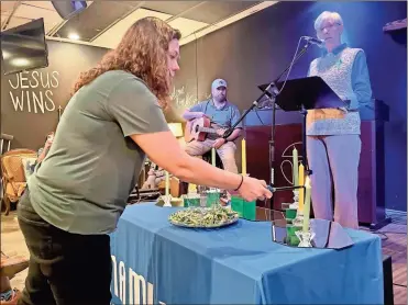  ?? David Crowder ?? Jenny Patrick with NAMI Rome lights the candle of truth during Tuesday’s candleligh­t service at the Church at Rome.