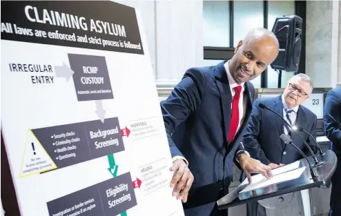 ?? PAUL CHIASSON / THE CANADIAN PRESS ?? Immigratio­n Minister Ahmed Hussen holds a press conference in Montreal Monday on the situation of irregular migration into Canada as Public Safety Minister Ralph Goodale looks on.