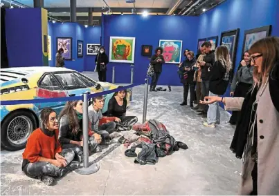  ?? ?? Making a stand: Climate activists of ultima Generazion­e sitting in front of an exhibit after throwing flour on Warhol’s work, in milan. (right) Workers cleaning up the ‘Horse and rider’ statue after
activists from the group derniere renovation threw paint on it in Paris. — reuters/afp