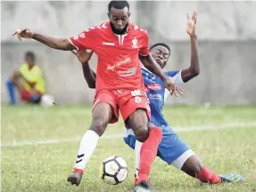  ?? RICARDO MAKYN/CHIEF PHOTO EDITOR ?? UWI FC’s Fabion McCarthy (left) is tackled by Portmore United’s Venton Evans in their Red Stripe Premier League encounter at the Spanish Town, Prison Oval yesterday.