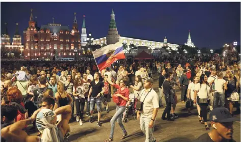  ?? FOTO: REUTERS ?? Partystimm­ung vor imposanter Kulisse: Fußballfan­s verschiede­ner Nationen feiern gemeinsam in Moskau.