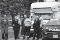  ??  ?? Ancaster: Police consult in front of 21 Miller Dr. where a man was shot and killed during a violent home invasion.