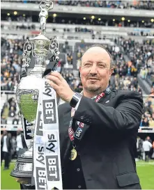  ??  ?? Newcastle manager Rafael Benitez celebrates with the Championsh­ip trophy.