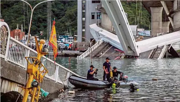  ?? (Foto EPA) ?? Petugas penyelamat melancarka­n operasi mencari mangsa yang hilang dipercayai warga Filipina dekat Jambatan Nanfangao, semalam.