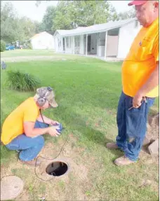  ?? TIMES photograph by Annette Beard ?? Ronnie Hicks and Curtis Wiltgen of the Pea Ridge Water Department listen for leaks in water lines. The two have fine-tuned the skill and are excellent at finding water leaks, according to Ken Hayes, superinten­dent.