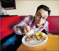  ?? — POSTMEDIA NEWS ?? You Gotta Eat Here! host John Catucci samples a plate of food called Remedy in Toronto.