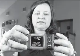  ?? David J. Phillip Associated Press ?? BECAUSE insulin pumps cost thousands of dollars and play a life-or-death role in people’s lives, switching manufactur­ers isn’t a decision you make lightly. Above, Stephanie Rodenberg-Lewis of Katy, Texas, holds her Animas Corp. insulin pump.