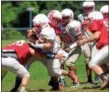  ?? TANIA BARRICKLO — DAILY FREEMAN ?? Alex Nesel, left, and Connor Redmond tackle Ernie Churchill during recent Red Hook practice.