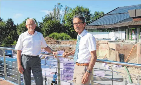  ?? FOTOS: GR ?? Der Chef der Bädergesel­lschaft, Willi Gresser, und Oberbürger­meister Karl Hilsenbek (von links) vor der Baustelle beim Wellenbad. Dort wird gerade die Bodenplatt­e für den Anbau gebaut.