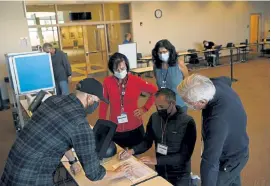  ?? Rachel Ellis, The Denver Post ?? Evan Siebring, lead election logistics coordinato­r, left, shows electoral technician judges and supervisor­s how to check electronic voting machines to ensure they aren’t tampered with in preparatio­n for early voting next week at the Englewood Civic Center on Thursday.