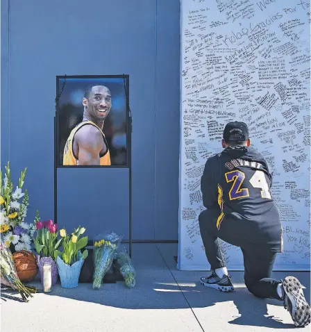  ?? HARRISON HILL/ USA TODAY ?? Los Angeles residents and fans write notes and mourn the loss of Kobe Bryant in front of the Lakers’ practice facility Monday.