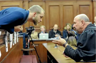  ?? AP ?? Henri van Breda, left, talks to one of his legal adviser, Piet Botha, right, in the High Court in Cape Town, South Africa, as he awaited the verdict in his murder, and attempted murder trial.