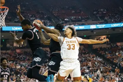  ?? AP Photo/Michael Thomas ?? Texas forward Tre Mitchell, right, goes up for a rebound against Oklahoma State guard Issac Likekele, center, and guard Bryce Thompson, left, Saturday during the first half of an NCAA college basketball game in Austin.