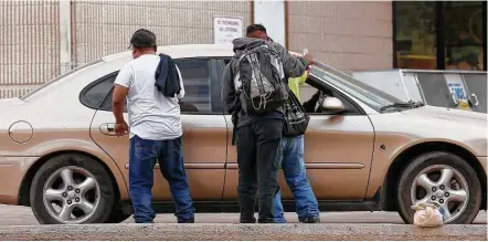  ?? Godofredo A. Vásquez / Houston Chronicle ?? Tres jornaleros se aproximan a un vehículo en busca de trabajo en una gasolinera de Houston, el martes 21 de noviembre.