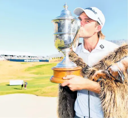  ??  ?? Zach Murray kisses the Brodie Breeze Trophy after winning by two shots in Queenstown yesterday.
