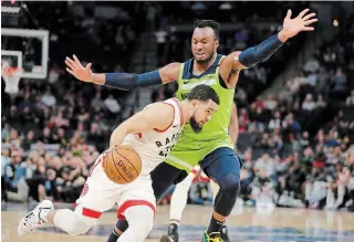  ?? ANDY CLAYTON-KING THE ASSOCIATED PRESS ?? Fred VanVleet, front, drives against Timberwolv­es’ Josh Okogie on Saturday in Minneapoli­s.