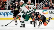  ?? [AP PHOTO/MARK J. TERRILL, FILE] ?? Anaheim Ducks right wing Ondrej Kase, right, of the Czech Republic, passes the puck past Minnesota Wild left wing Jordan Greenway, center, as Ducks center Adam Henrique, left, watches during the third period of an NHL game in Anaheim, Calif., on Tuesday.