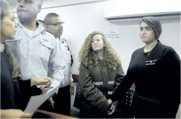  ?? THE ASSOCIATED PRESS ?? Ahed Tamimi, centre, is seen at a court inside the Ofer military prison near Jerusalem in December. The 17- year- old Palestinia­n girl faces court on Tuesday on charges of assault and incitement.