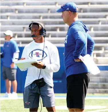  ?? Submitted photo ?? ■ Eric Sutton, a student assistant at Louisiana Tech, converses with Bulldog head coach Skip Holtz during a team practice. Sutton was the equipment manager for two seasons at La. Tech before he was promoted to student assistant with the running backs.