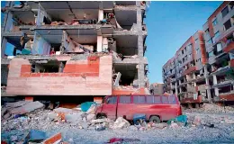  ?? AFP ?? A damaged van and buildings following a 7.3-magnitude earthquake at Sarpol-e Zahab in Iran’s Kermanshah province on Monday. —