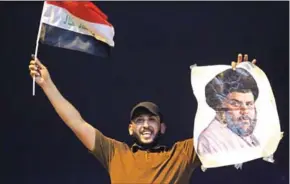  ?? AHMAD AL-RUBAYE/AFP ?? An Iraqi man celebrates with a picture of Shiite cleric Muqtada Sadr during the general election in Baghdad on May 14.