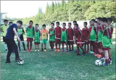  ?? PROVIDED TO CHINA DAILY ?? Above: Xu Genbao with his former pupil, Shanghai SIPG striker Wu Lei, at the 2018 Chinese Super League awards ceremony in Haikou last November. Below: A batch of recent recruits are coached at Xu’s academy on Chongming Island, Shanghai.