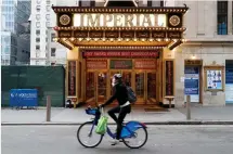  ?? (Reuters) ?? A CYCLIST rides pasted the shuttered Imperial Theater on Broadway.