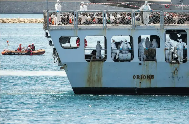  ?? PABLO BLAZQUEZ DOMINGUEZ / GETTY IMAGES ?? Italian navy vessel Orione arrives carrying migrants Sunday at Spain’s port of Valencia, the third of three rescue ships to dock at the port that day.