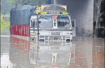  ?? HT PHOTOS ?? A truck stuck in Industrial Area, Phase 1, in Chandigarh, and (below) residents on a waterlogge­d street in Sector 77, Mohali, after heavy rain on Thursday morning.