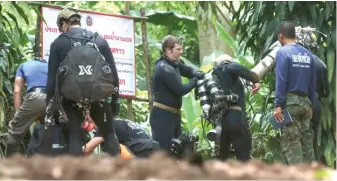  ?? SAKCHAI LALIT/ AP ?? Internatio­nal rescuers prepare Thursday to enter the cave where a young soccer team and their coach remain trapped by flood waters in Mae Sai, Chiang Rai province, in northern Thailand.